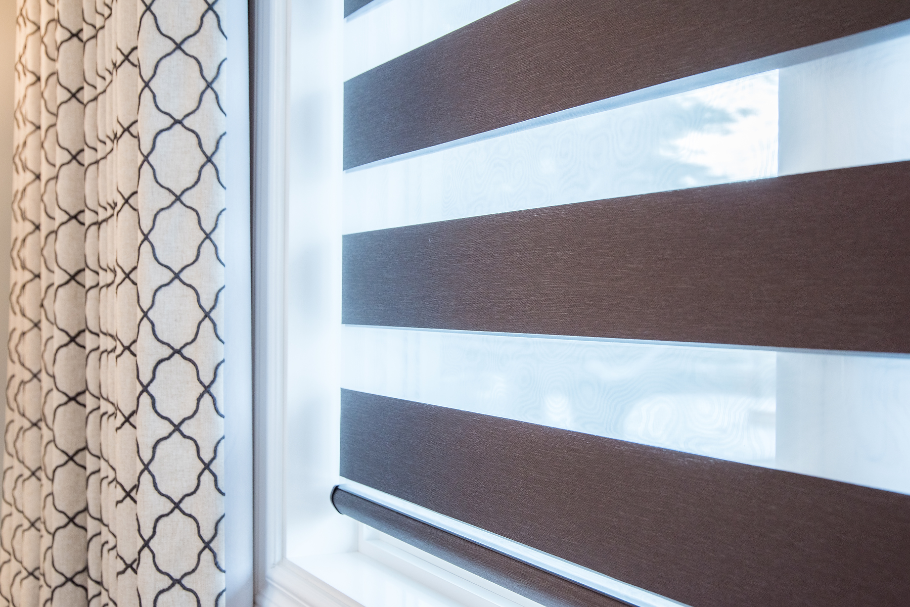 Transitional blinds and classic patterned drapes in bedroom