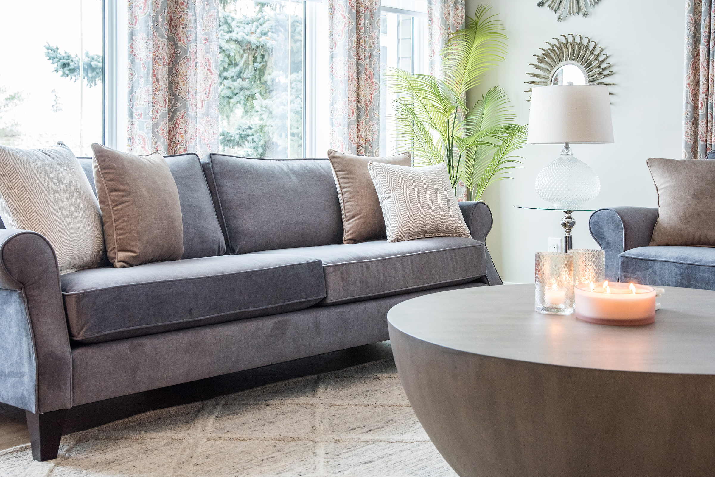 Dark grey velvet custom sofa with panel drapes on windows. an Edmonton home renovation. Interior decorating by Sovereign Style interiors